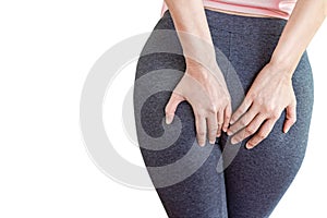 Woman hand holding her painful butt caused by hemorrhoids