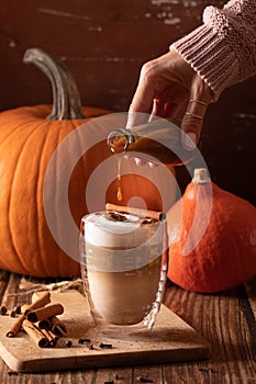 Woman hand holding homemade pumpkin spice latte made from scratch