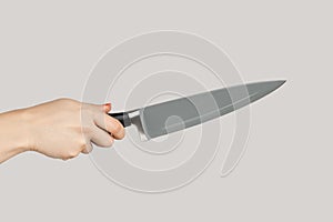 Woman hand holding huge sharp kitchen knife.