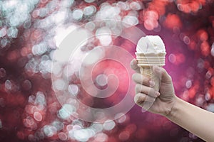 A woman hand holding Ice cream cone with abstract bokeh background,filtered image,colorful picture style