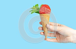A woman hand holding an ice cream cone with watermelon and mint