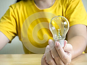 Woman hand holding light bulb, concept of new ideas with innovation and creativity