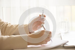 Woman hand holding light bulb on cream background with copy space. Creative idea, new business plan, motivation