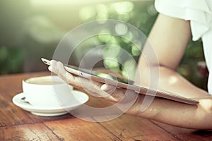 Woman hand holding and looking on digital tablet in coffee shop