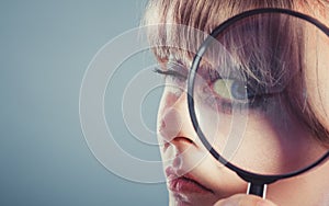 Woman hand holding magnifying glass on eye