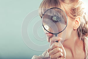 Woman hand holding magnifying glass on eye