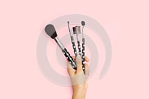 Woman hand holding make up brushes