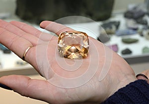 Woman hand holding natural brown zircon mineral photo