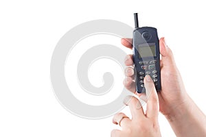 Woman hand holding old mobile phone and presses buttons isolated on white background