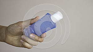 Woman hand holding one plastic bottle of alcohol gel. Copy space area fr text