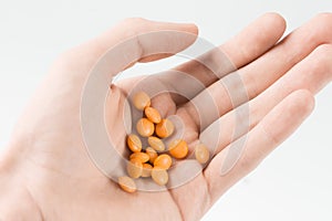 Woman hand holding orange pills before doing suicide
