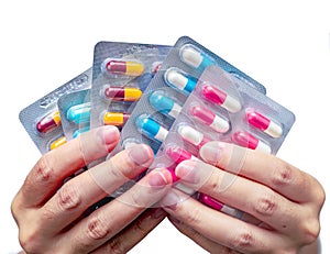 Woman hand holding pack of antibiotic capsule pills isolated on white background. Giving or receiving drug. Antibiotic drug