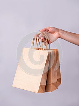 Woman hand holding paper bag  on gray background