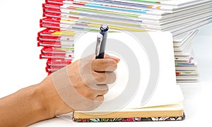 Woman hand holding pen writing on book.