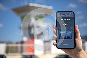 Woman hand holding phone with airplane ticket application airlines on screen