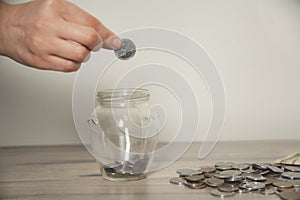 Woman hand holding piggy bank and coin