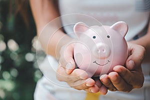 Woman hand holding piggy bank, saving, charity, fundrasing community care