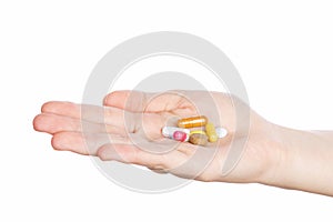 Woman hand holding pills on white
