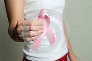 Woman hand holding pink ribbon breast cancer awareness