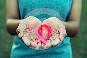 woman hand holding pink ribbon breast cancer awareness