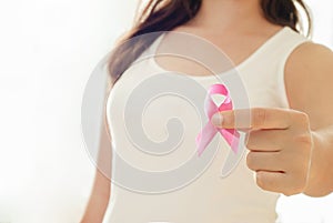 Woman hand holding pink ribbon, breast cancer awareness concept, healthcare and medicine