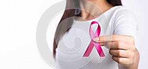 Woman hand holding pink ribbon breast cancer awareness. concept healthcare and medicine