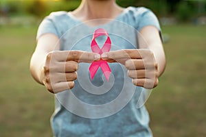 woman hand holding pink ribbon breast cancer awareness