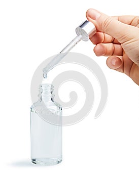 Woman hand holding pipette with collagen moisturizing hyaluron serum in a glass bottle