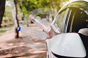 Woman hand holding plastic bottle on the road,Global warming environmental protection concept,Close up