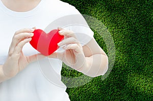 Woman hand holding plush a red heart at left her chest