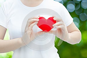 Woman hand holding plush a red heart at left her chest ,Valentine day concept