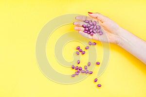 Woman hand holding purple pills handful
