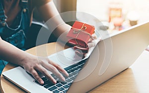 Woman hand holding red gift box about shopping online concept.