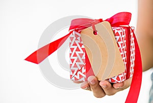 Woman hand holding a red gift box with tags card copy space