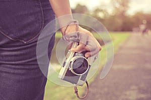 Woman hand holding retro camera. young hipster girl photographer with film camera