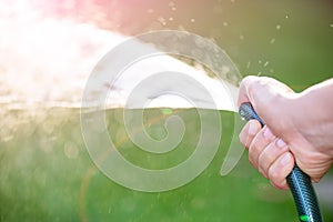 Woman hand holding rubber water hose