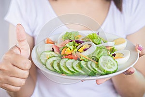 Woman hand holding salad dish eating healthy food closeup