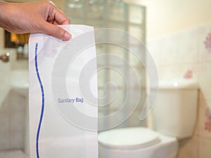 Woman hand holding sanitary bag