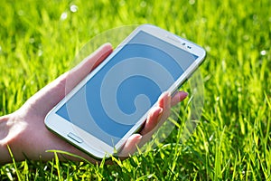 Woman Hand Holding Smart Phone on Green Background