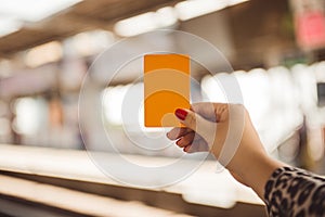 Woman hand holding smartcard for mrt or train on blurred of train station