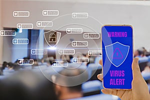 Woman hand holding smartphone in hand,red screen and shield icon virus corona alert security,auditorium background,concept