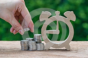 Woman hand holding stack of coins money putting on stack of coin