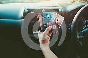 Woman hand holding tape cassette in car for driving listen music