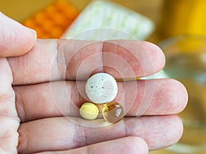 Woman hand holding three pills in the palm, close up. To get sick, take pills or undergo treatment photo