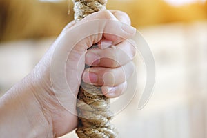 Woman hand holding on to the rope,