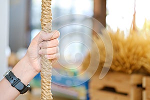 Woman hand holding on to the rope,
