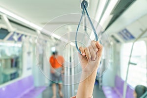 Woman hand holding the train rails while taking sky train.