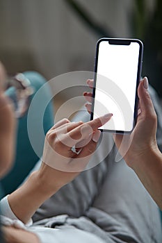 Woman hand holding using touch mobile phone white screen mockup Back view