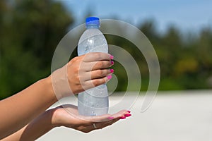 Woman hand holding water bottle outdoors
