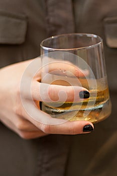 Woman hand holding a whisky glass